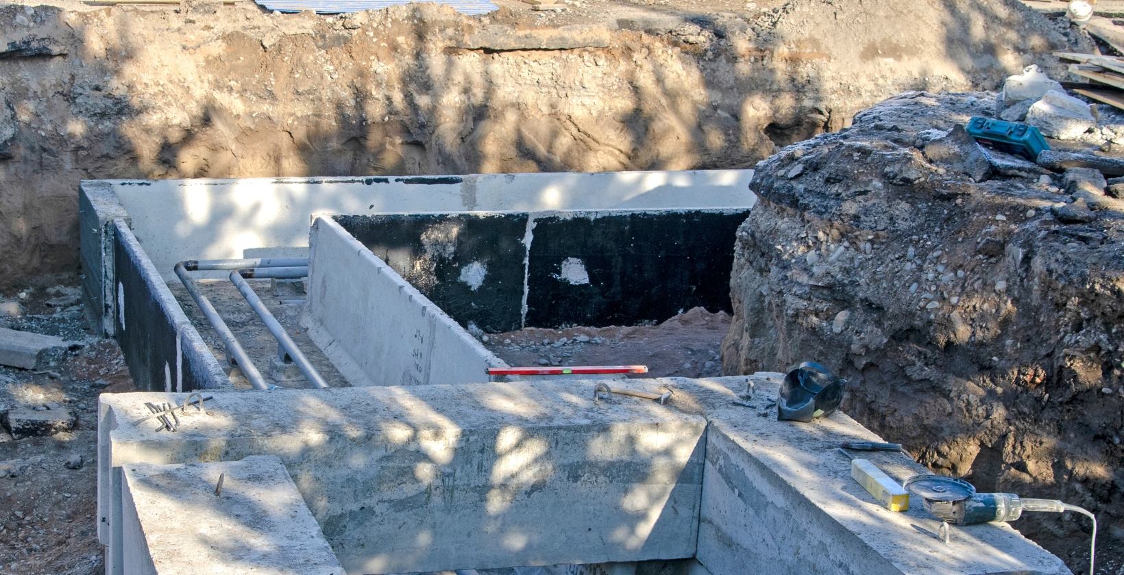 Open trench with ducting and buried service pipework, illustrating underground gas mains between buildings on large Derby sites