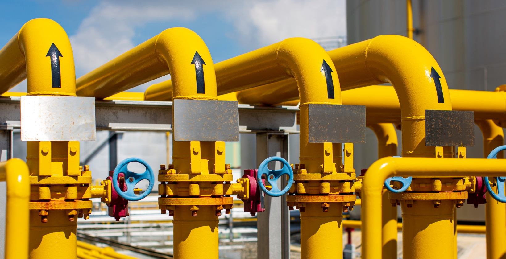 Yellow gas pipework with flow direction arrows and blue isolation valves, showing the sectional isolation used on Sheffield industrial sites