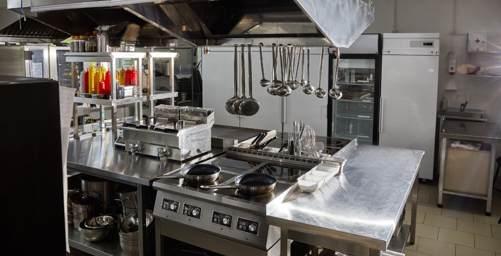 Commercial Catering Gas Services | Commercial Gas Pipework Stainless steel commercial kitchen with cooking range, fryers and extraction canopy