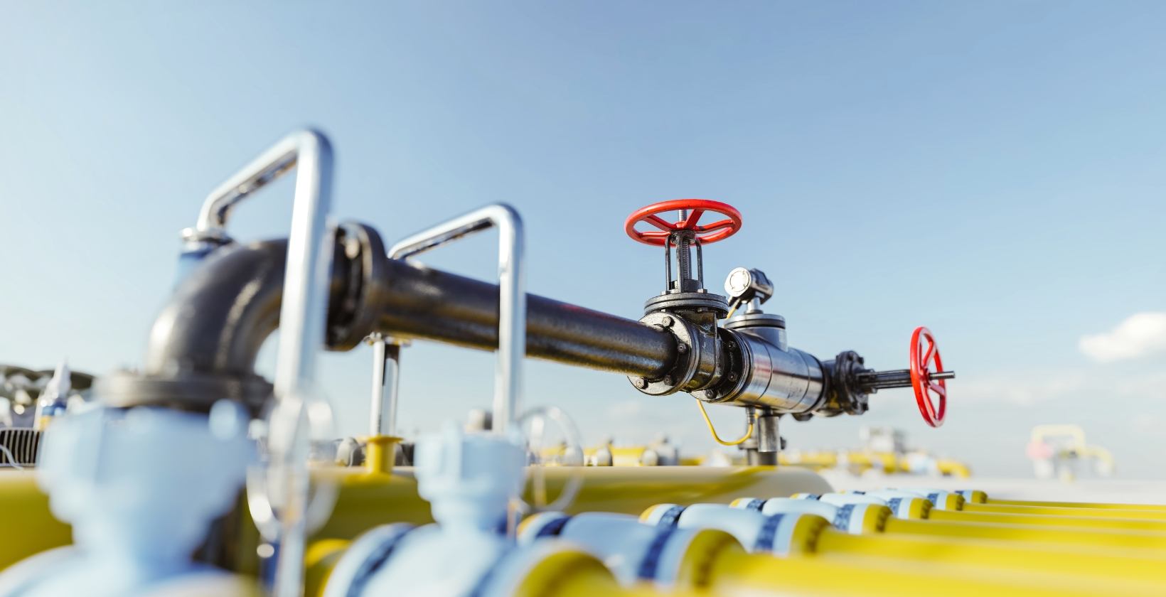 Gas Hot Tapping Services | Commercial Gas Pipework Live gas pipeline with red handwheel isolation valves and pressure gauge at an outdoor gas facility